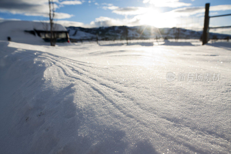 雪的特写与栅栏和山脉