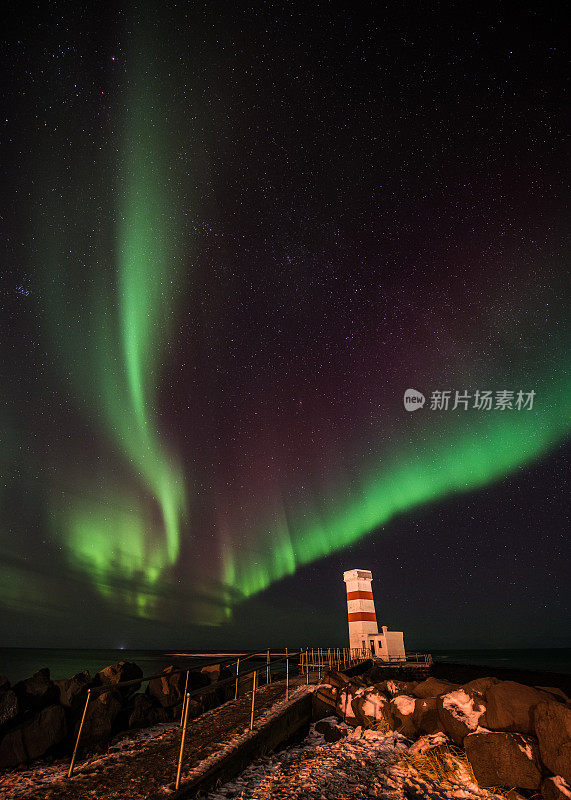 冰岛灯塔上方的北极光