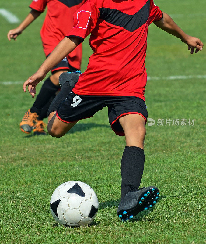 一个年轻的足球运动员踢球