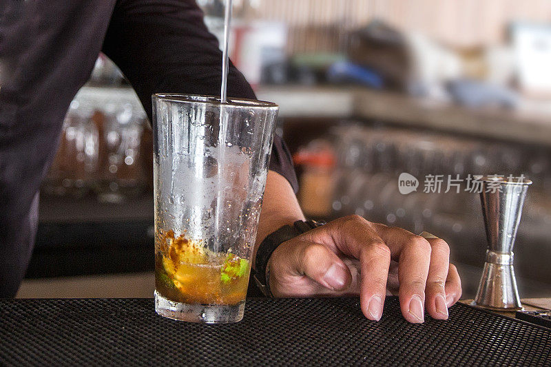 男酒保将酒精倒入鸡尾酒中