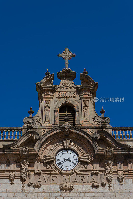 教堂屋顶的细节，时钟，十字架和“圣母玛利亚”雕刻在石头上