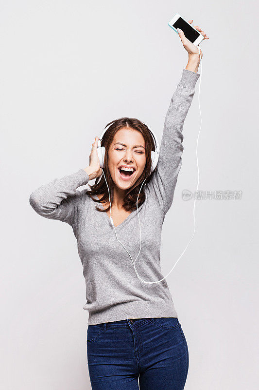 快乐的年轻女子享受音乐