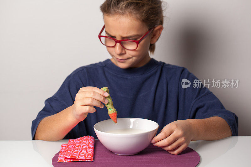 心烦意乱的小女孩在吃万圣节早餐