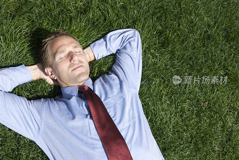 商人躺在草地上，双手放在脑后