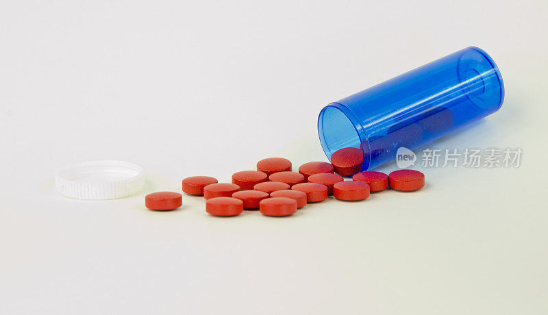 蓝色的药瓶，白色的上面有红色的药丸