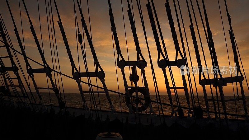 透过旧帆船的索具看日落