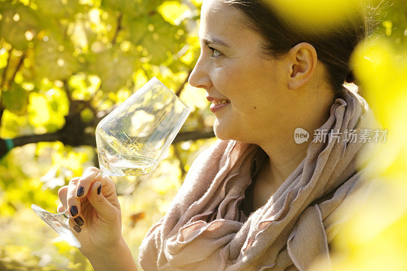 女酿酒师与一杯白葡萄酒在葡萄园
