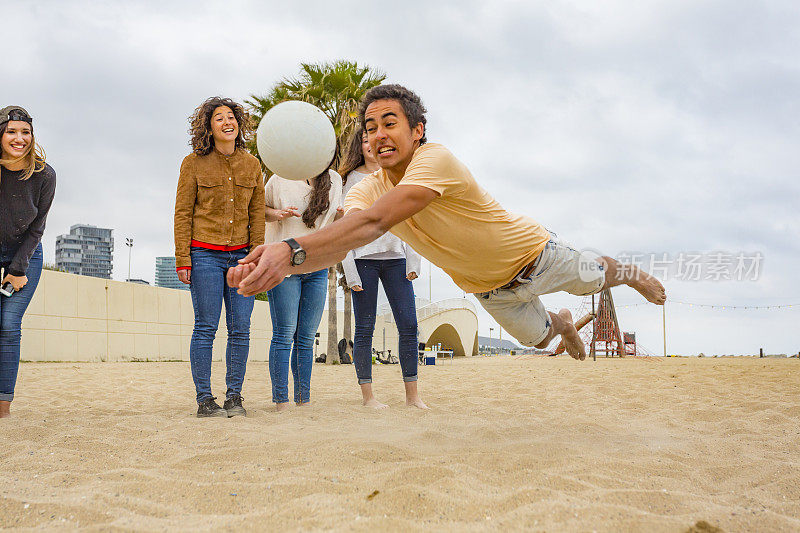 活跃的年轻人在玩沙滩排球时跳跃