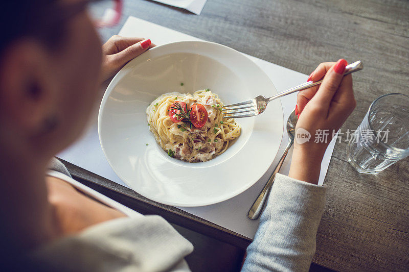 上图是一名女子午餐吃意大利通心粉。