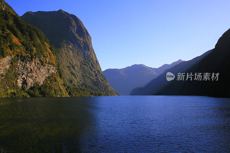 瀑布和雄伟的可疑之声峡湾在金色的戏剧性日落，田园诗般的峡湾景观，南新西兰全景