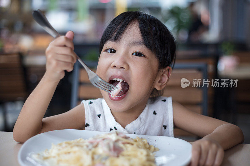 亚洲华人小女孩在吃意大利面