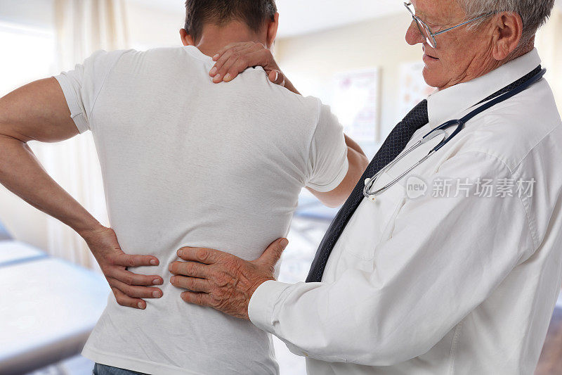 男医生和病人在体检时背部疼痛。