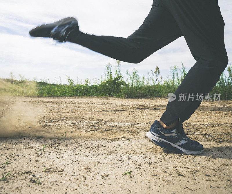 跑步者迎着乌云在土路上奔跑