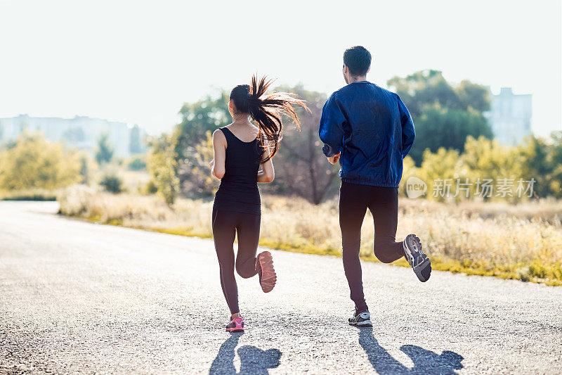 在阳光明媚的日子里，积极运动的女人和男人慢跑