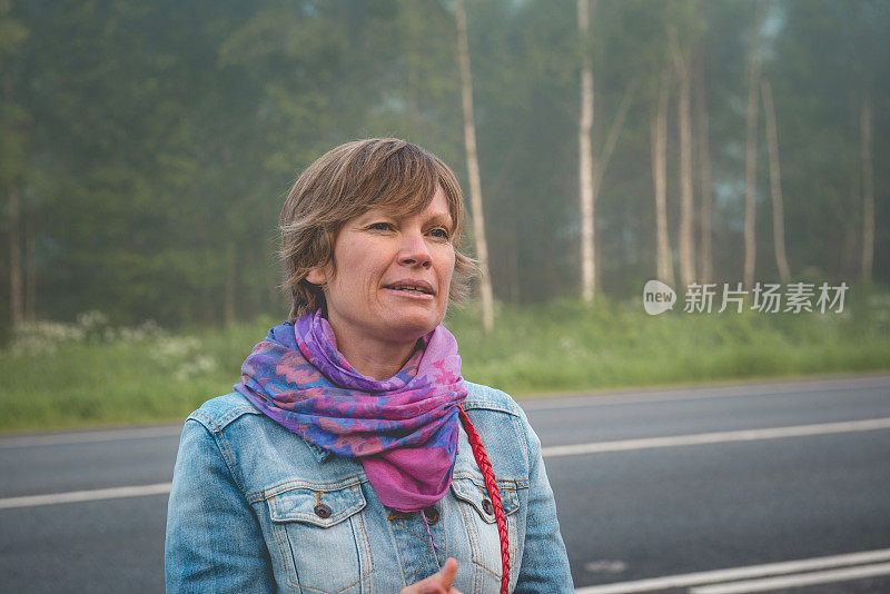 俄罗斯，大雾天气下，成熟女性在公交车站等车