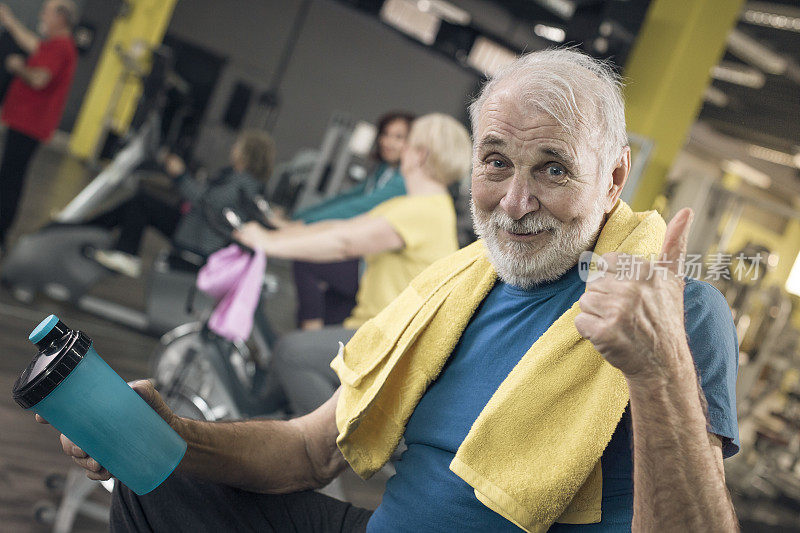 老男人在健身房里竖起大拇指