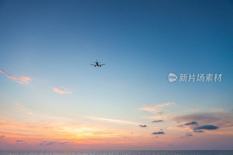 日落时飞机在海面上飞行