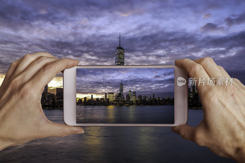 一个女人拿着手机在纽约曼哈顿拍照