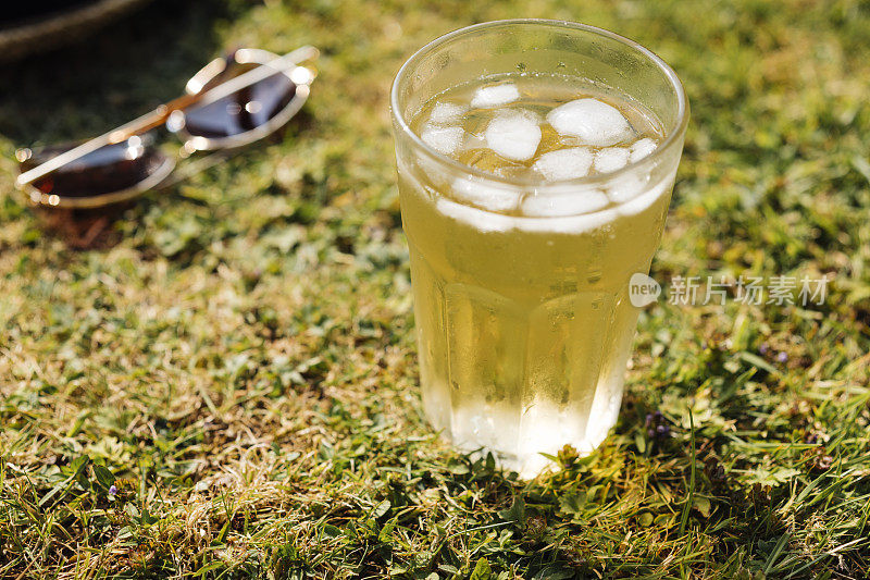 在一个炎热的夏天，在花园的草坪上喝一杯冰茶。