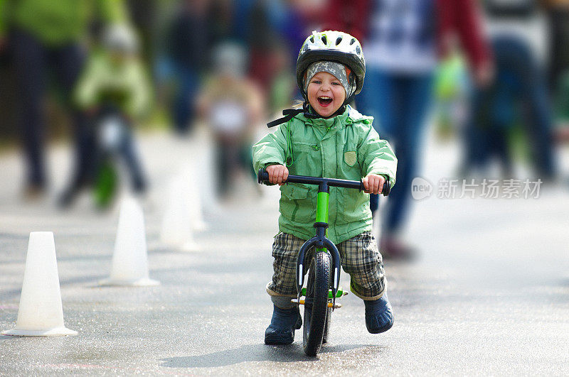 小男孩骑着跑步车