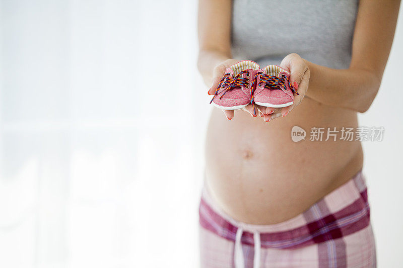 孕妇抱着刚出生的小鞋子