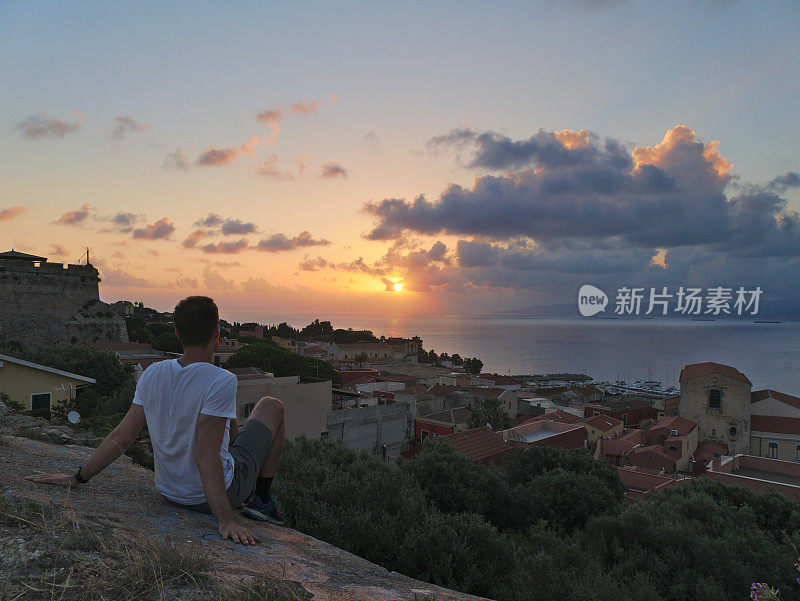 年轻人在海边小镇米拉佐和大海上看日出