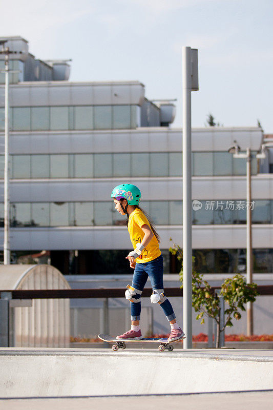 年轻的滑板女孩在城市滑板公园