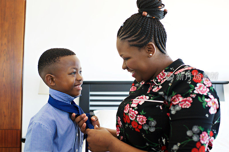 非洲母亲为儿子打扮学校时刻调整领带