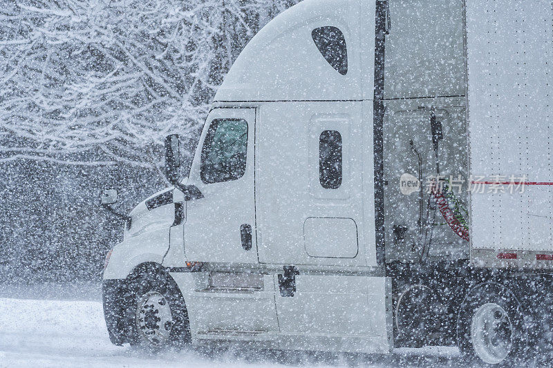 一辆半牵引车挂在暴风雪期间的乡间小路上