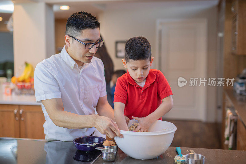 一个西班牙小男孩帮他爸爸烤饼干