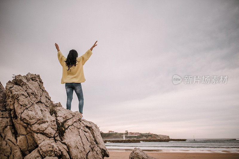 女人的后视图与手臂举起的大海