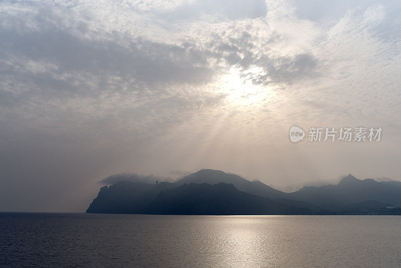 岩石海岸，卡拉达火山，阳光和多云的天空，克里米亚