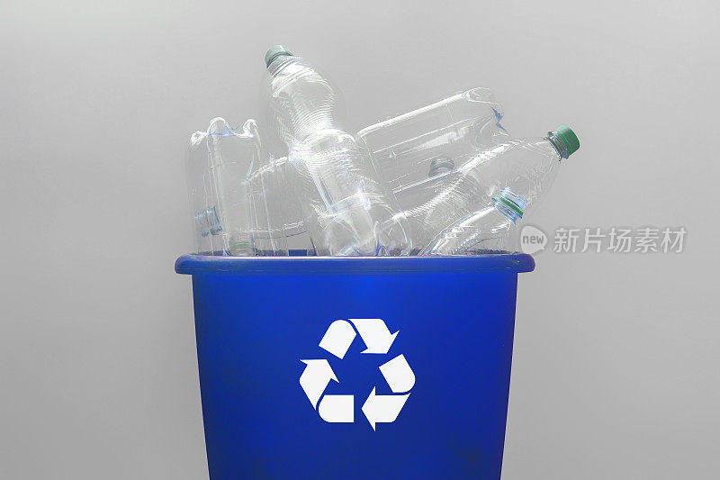 塑料瓶装在带有回收标志的蓝色回收盒内