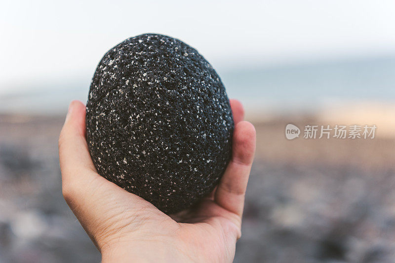 持有圣托里尼岛的黑色火山岩