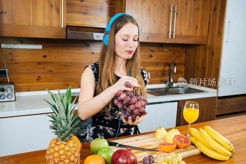 年轻女人在厨房里吃新鲜水果