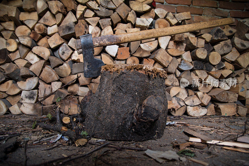 一把斧头卡在一堆木头前面的一根圆木上