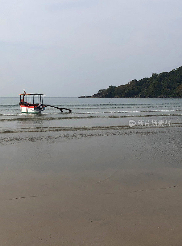 图片中的游船停泊在果阿海岸，准备清晨日出海豚观察巡航，果阿海滩，印度