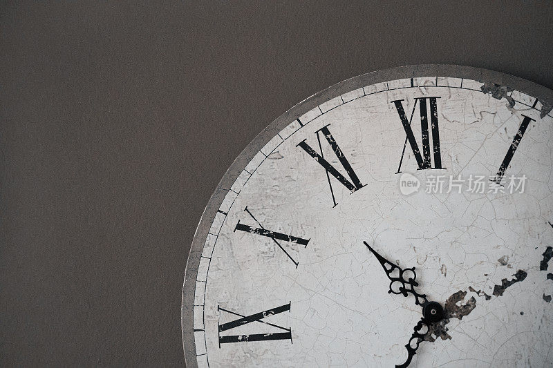 时间正在运行。一个挂钟在一个深灰色的墙壁背景，工作时钟，时间，拷贝空间-库存照片