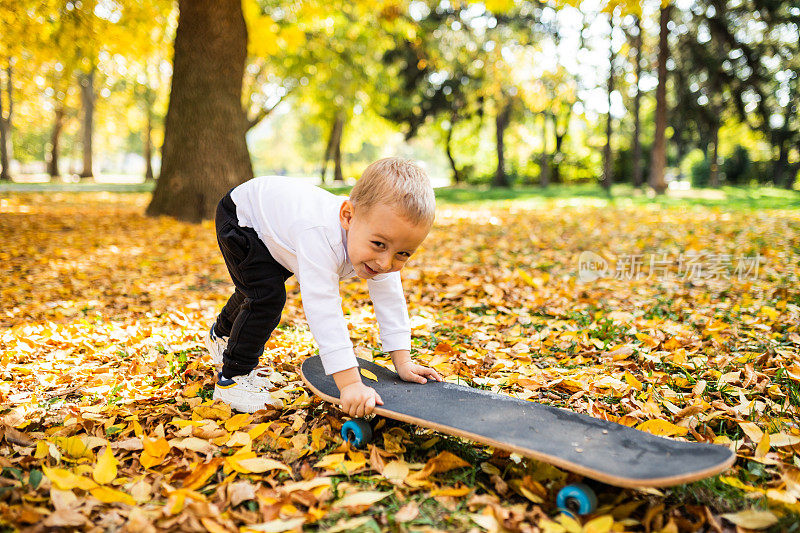 小男孩在公园里学滑滑板