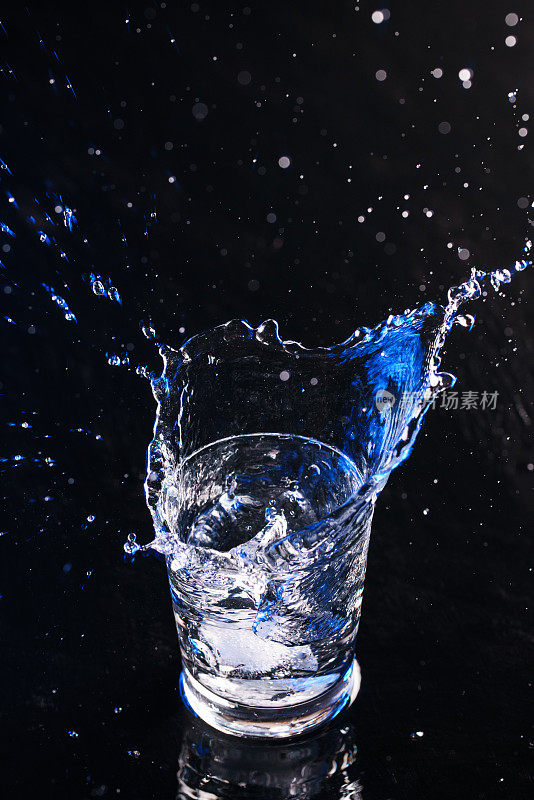 纯净水从玻璃杯里飞溅出来