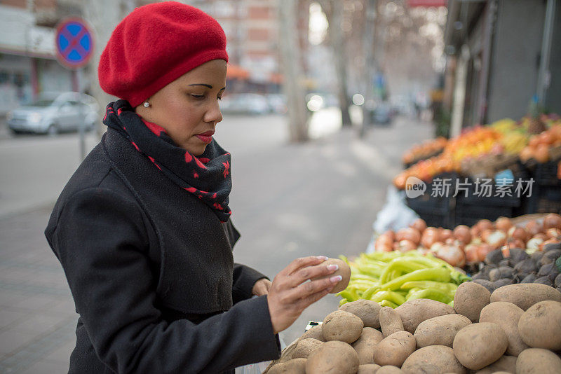 肤色不同的妇女在传统市场挑选蔬菜