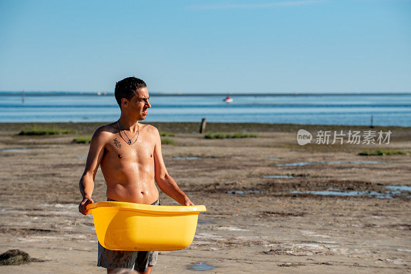 做白日梦的成年人穿着泳衣携带塑料容器在海滩库存照片
