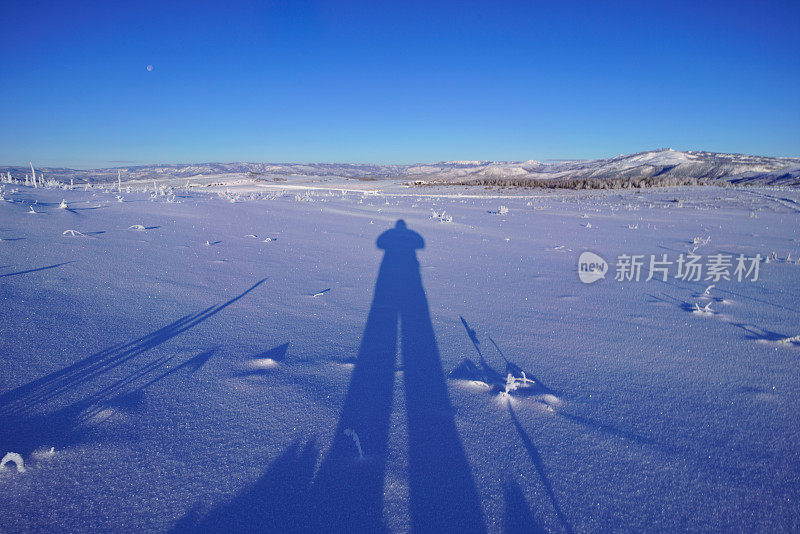 雪中的人的长长的影子