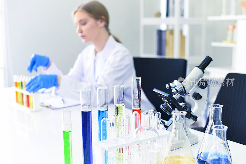 年轻的女科学家做一些研究工作在现代实验室进行实验和显微镜-科学家在实验室生物化学、遗传学、法医学、微生物学和试管
