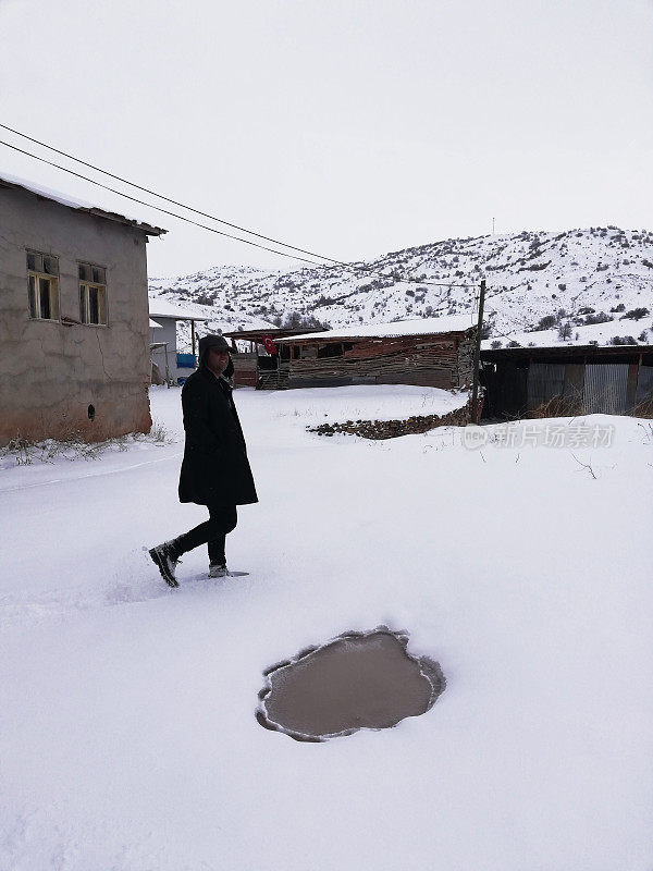 成年男子拿着步枪在雪地上行走