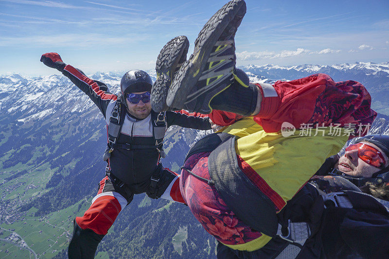 自由落体飞行者通过高山景观之上的崇高天空下降