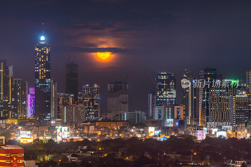 满月的景象和马尼拉马卡蒂市的建筑灯光