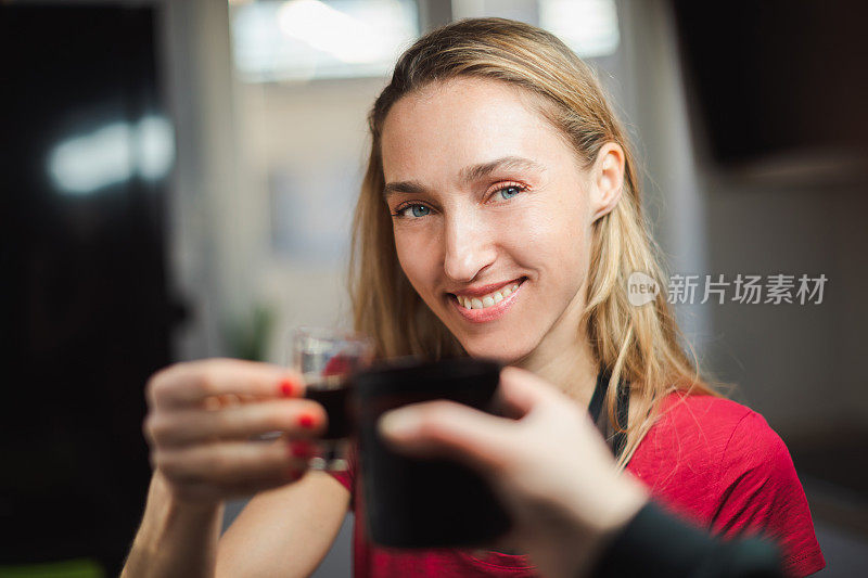 一个女人举起酒杯，看着她的朋友