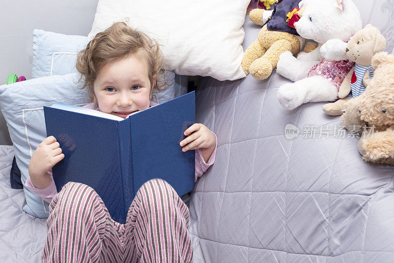 小女孩，白人5岁，读一本大精装书。
