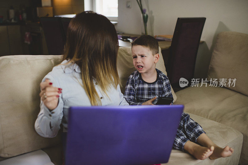 在隔离期间带着小儿子在家工作的妇女